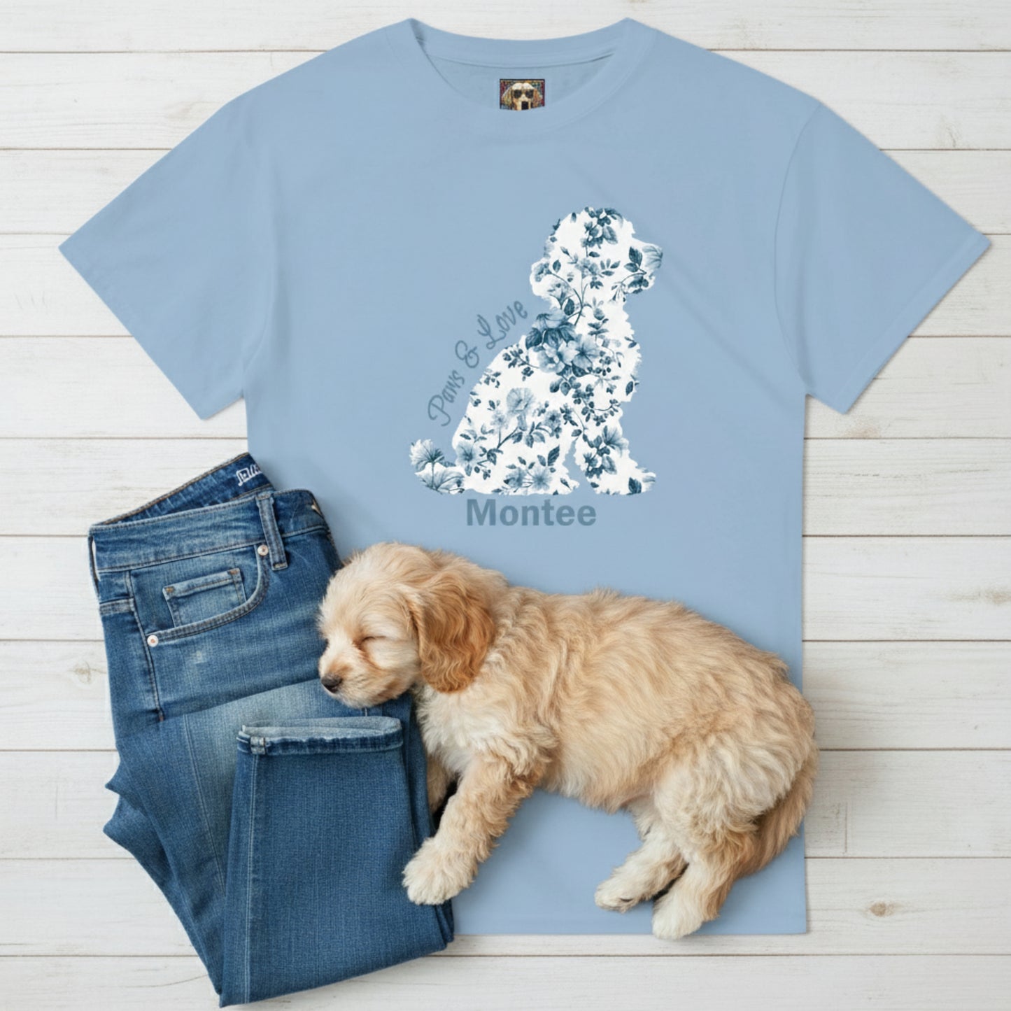 light Blue t-shirt with French floral dog shaped design and text, paired with blue jeans and a Cavoodle puppy on a wooden surface.