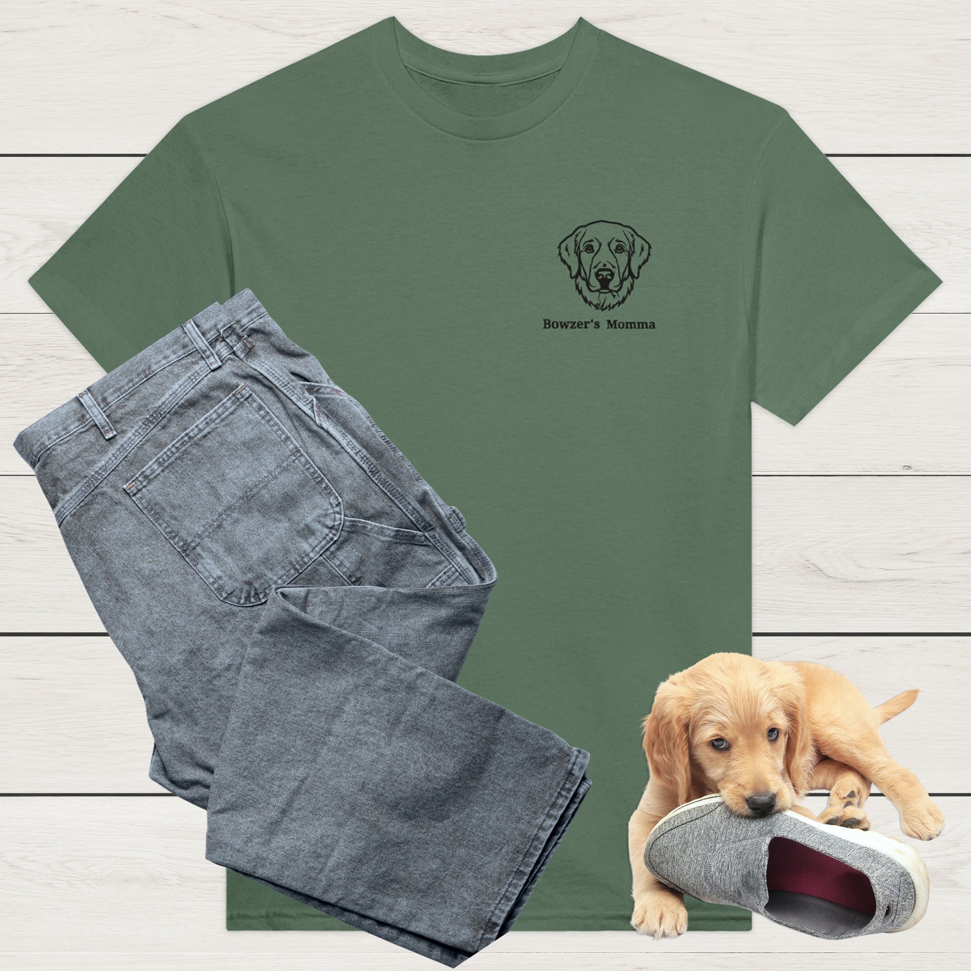 Military Green t-shirt with custom embroidery of a dog and personalised text along with wardrobe suggestion of blue jeans on a wooden surface, with a puppy playing with a shoe in the background.