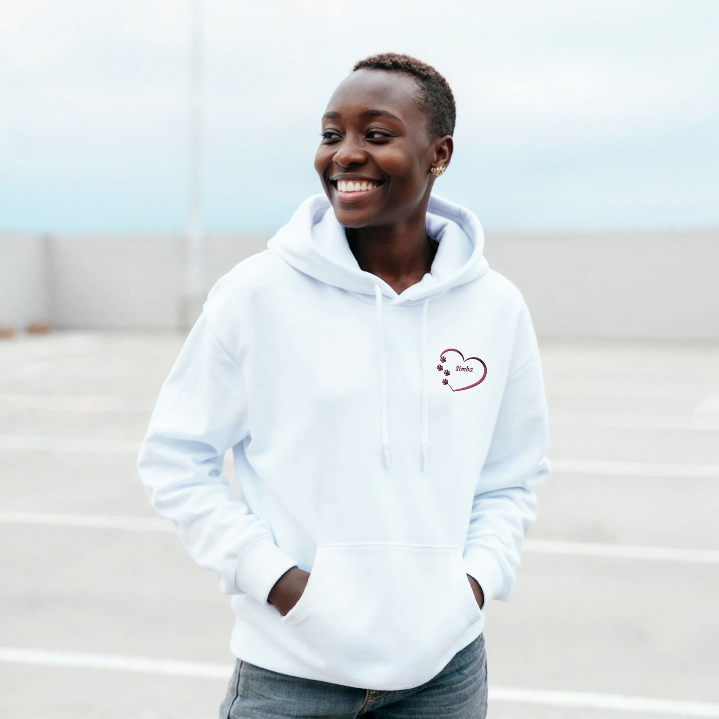 White Custom Embroidery, Heart Personalized with Pet's Name on a Pullover Hoodie Sweatshirt on woman walking in a parking area