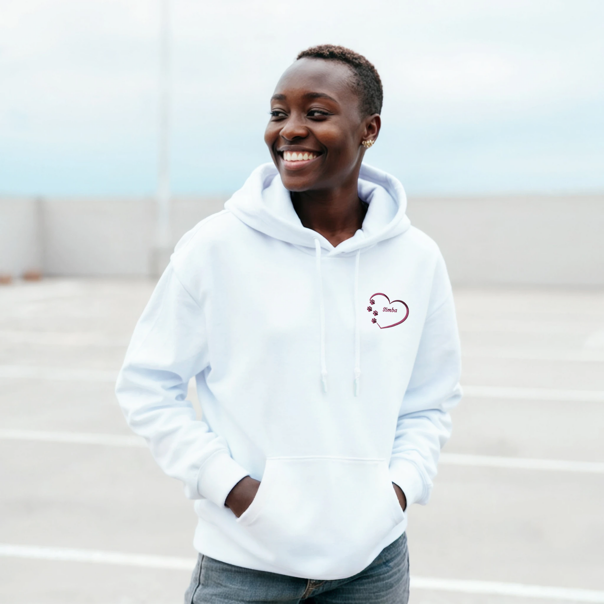 White Custom Embroidery, Heart Personalized with Pet's Name on a Pullover Hoodie Sweatshirt on woman walking in a parking area