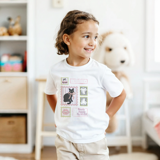 Child wearing a white t-shirt with a coquestte stamp Halloween graphic design in a room with a blurred background