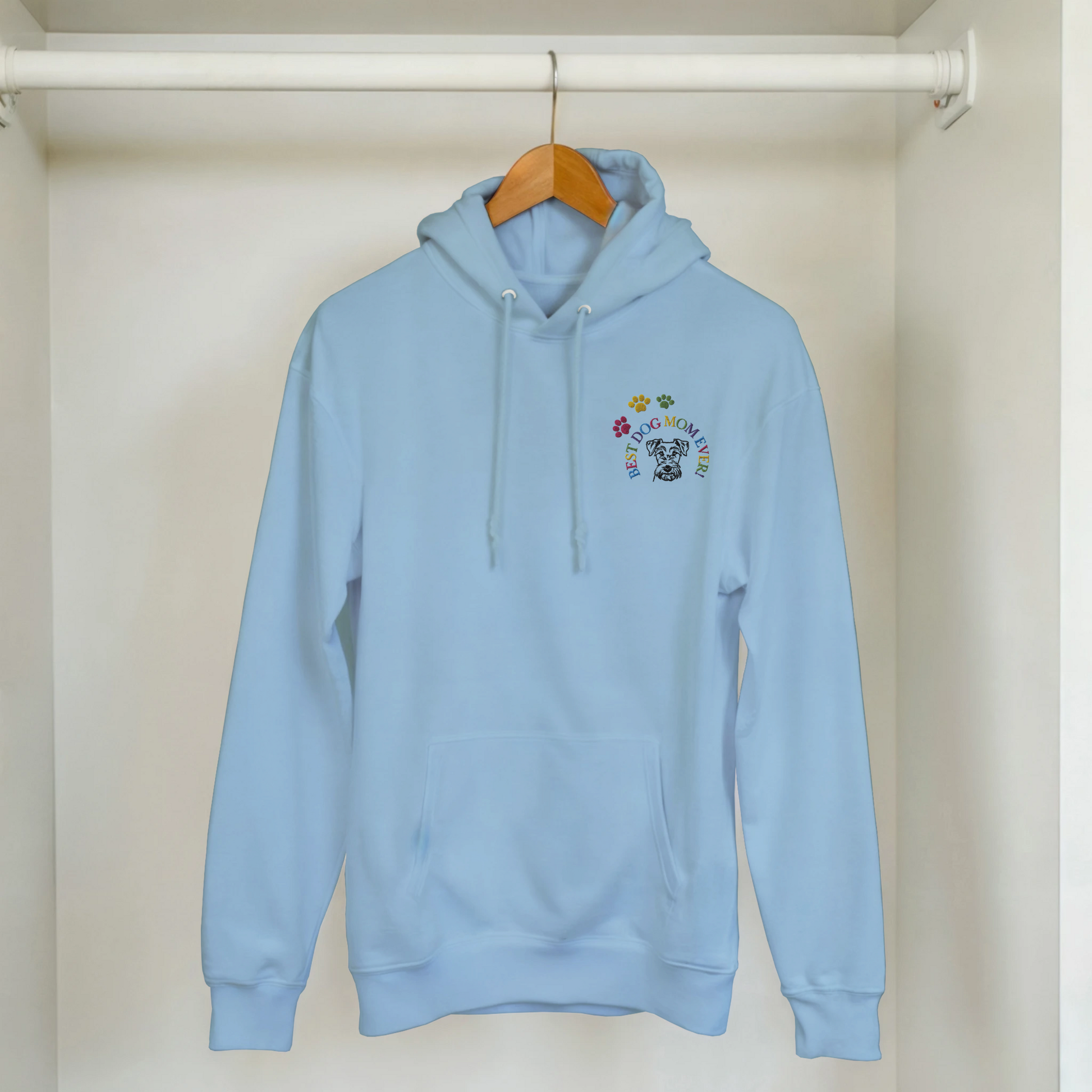 Custom Embroidered Classic Pullover Hoodie | Best Dog Mom Ever! A light blue hoodie hanging in a closet.