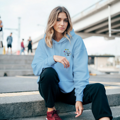 Custom Embroidered Classic Pullover Hoodie | Best Dog Mom Ever! A Woman in a light blue hoodie sitting on steps outside in a city.