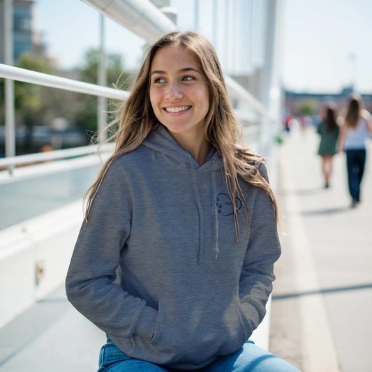 Custom Embroidery, Heart Personalized with Your Pet's Name on a Pullover Grey Hoodie Sweatshirt hearts inside blue thread. A young woman standing outside a building.