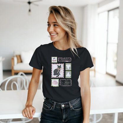 Woman getting ready for spooky season wearing a cute black t-shirt with a Halloween collage graphic design, standing in a bright living area.