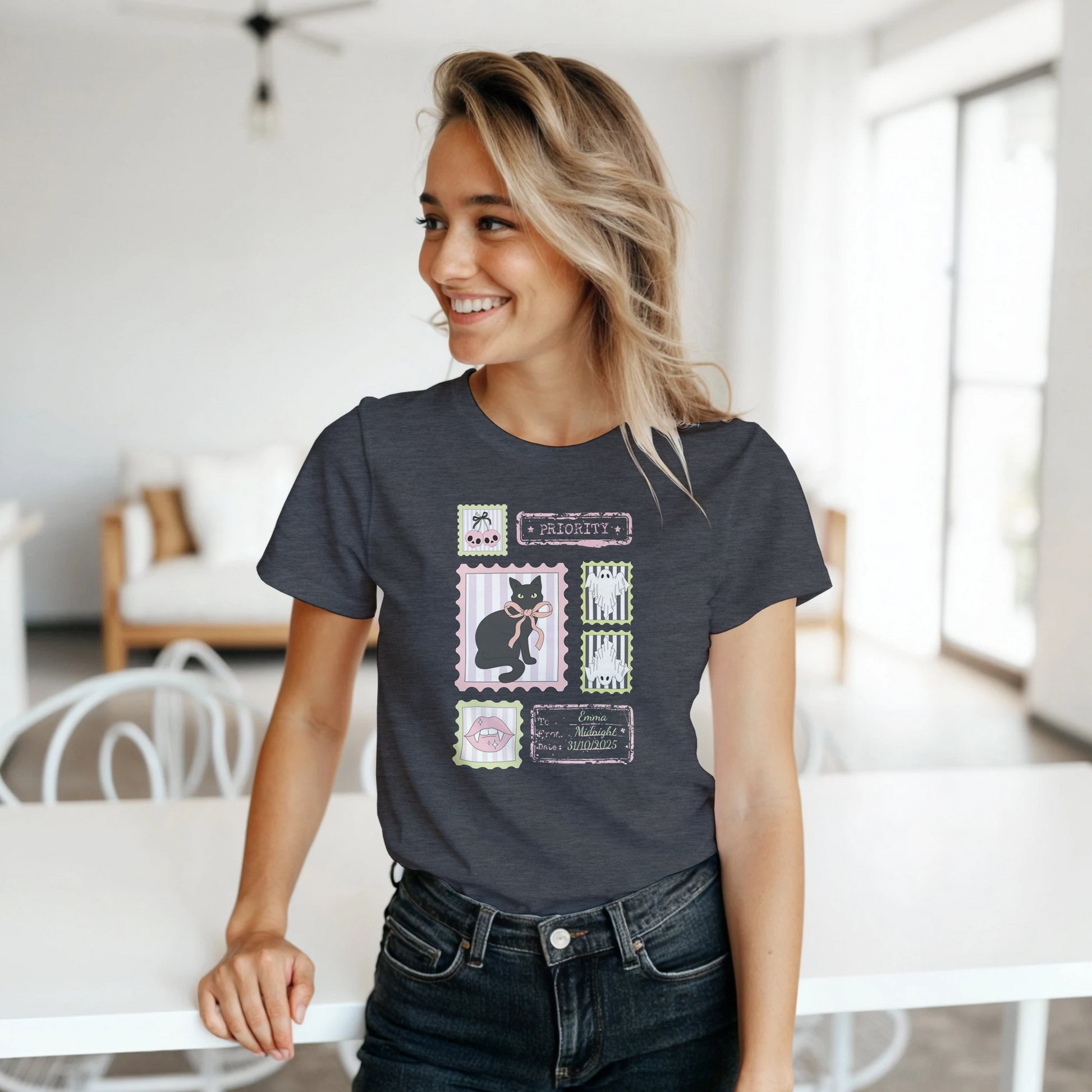 Woman wearing a dark gray Halloween stamps t-shirt and jeans while standing in a bright living area.