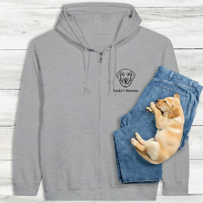 Gray classic zip hoodie with personalised embroidery of dog and text, and a puppy lying on blue jeans. Background is a light wooden surface