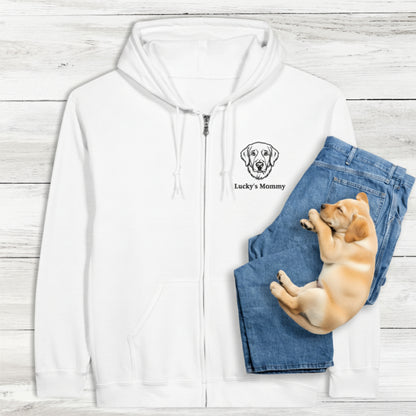 White classic zip hoodie with personalised embroidery of dog and text, and a puppy lying on blue jeans. Background is a light wooden surface