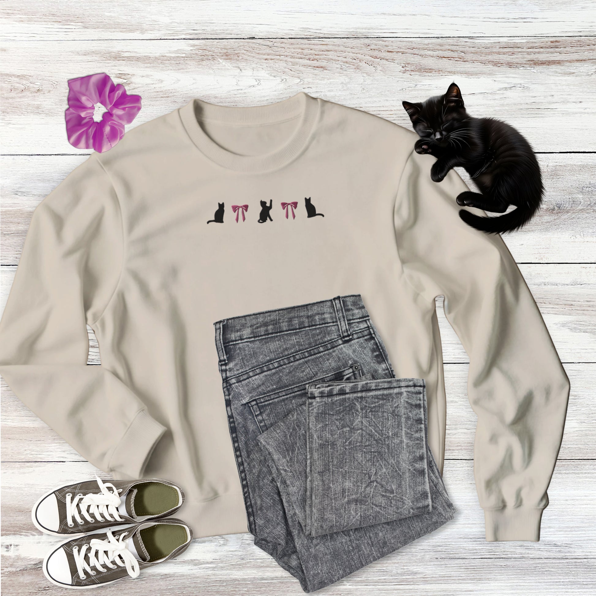 Embroidered Pink Bows and Black Cats Autumnal Gildan Sweatshirt in Sand, Light Tan, flat lay with outfit style suggestion and sweet black kitten sleeping.