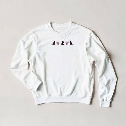 White sweatshirt with black cats and pink coquette bows emboirdered design flat on a light gray background