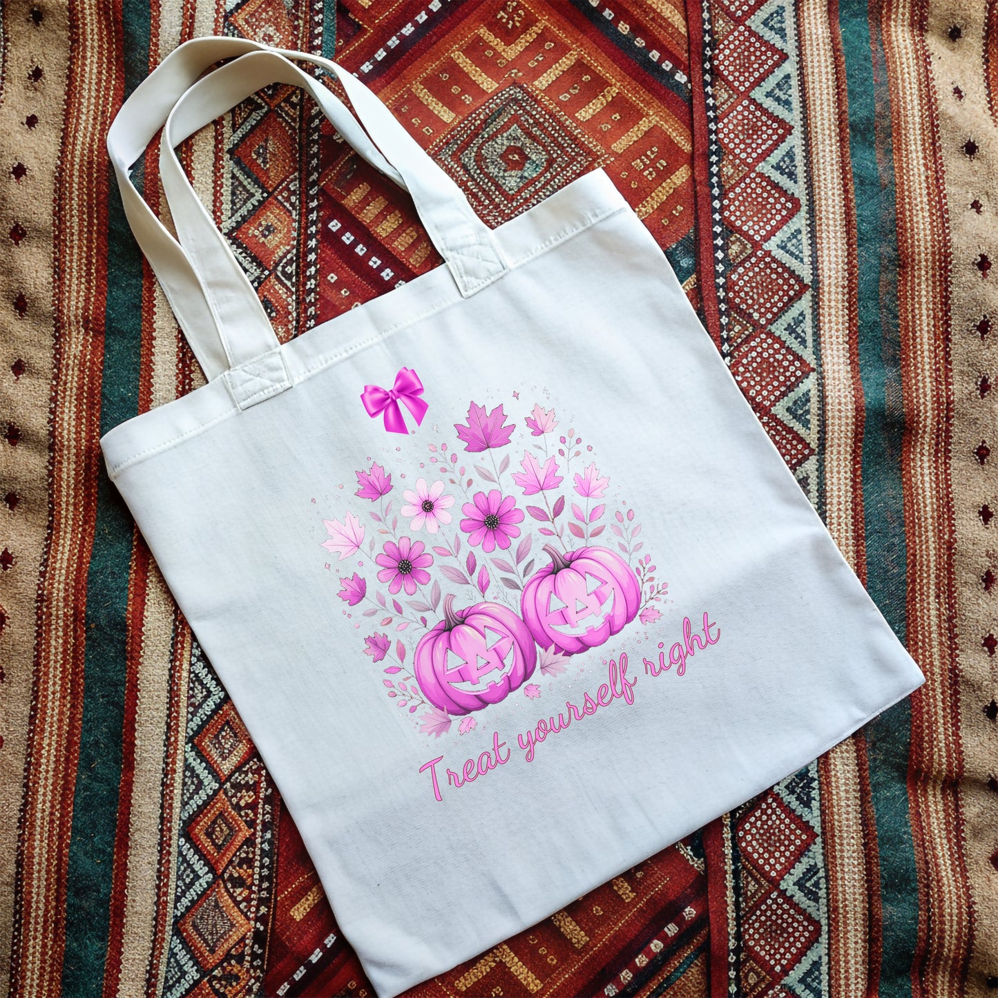 White tote bag with cute pink Halloween design and text on a a woven rug background
