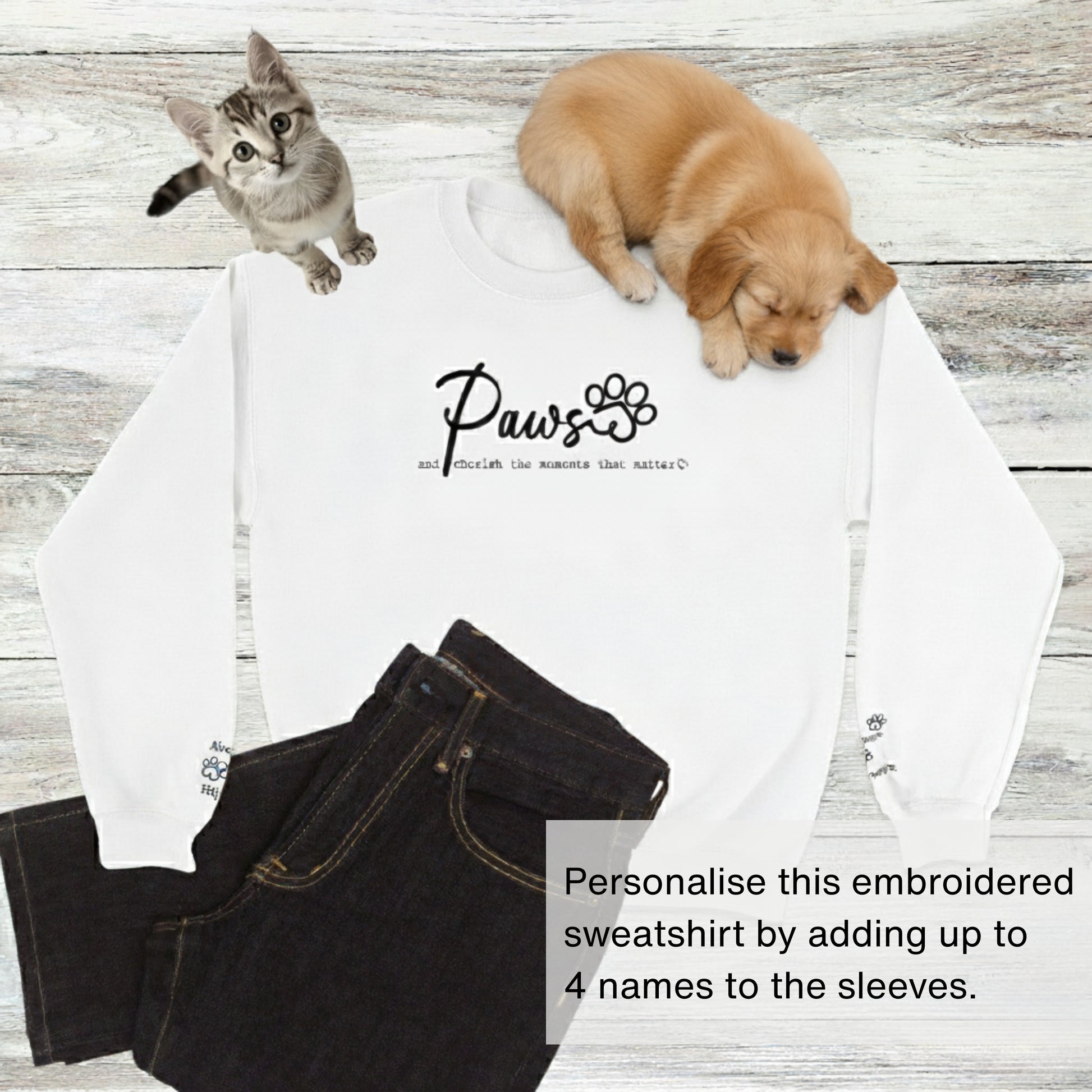 Custom embroidered crew neck pullover sweatshirt in white with black jeans, a kitten, and a cute puppy. 'Paws and cherish the moments that matter.'