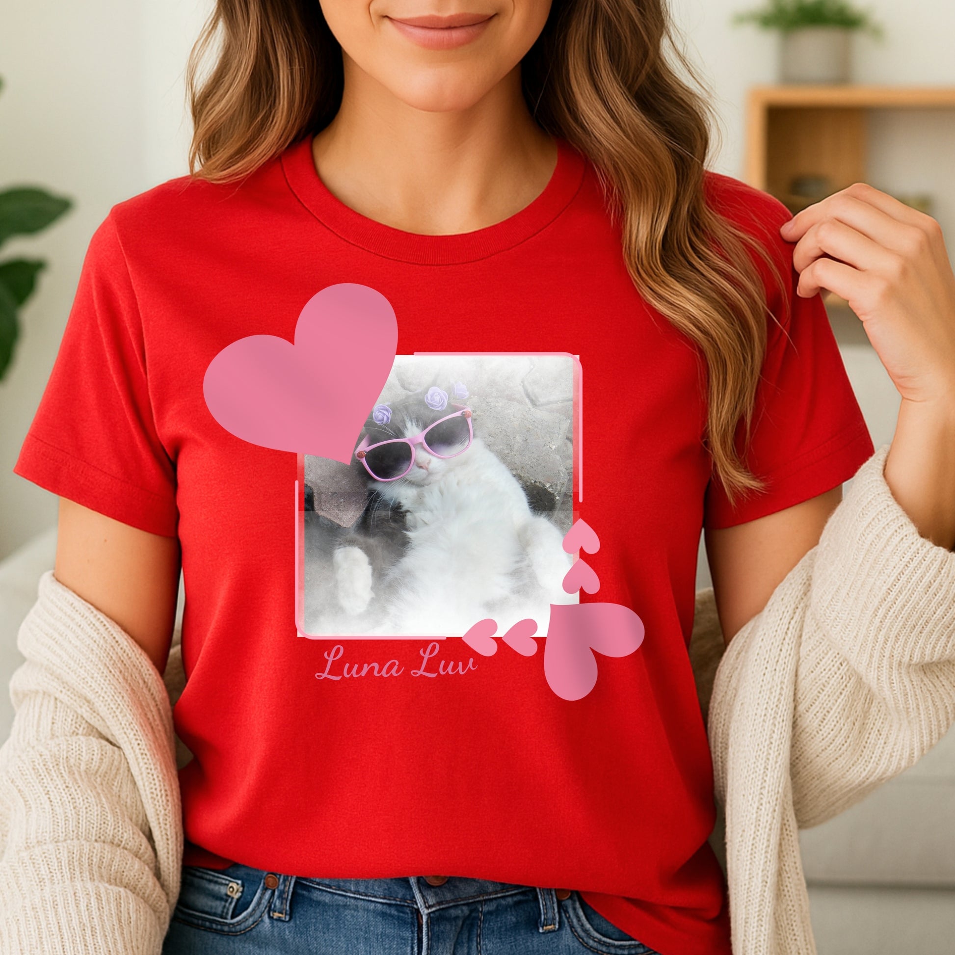 Woman wearing a red t-shirt with a heart frame graphic design with a photo of a cat in sunglasses with the cat's name below it.