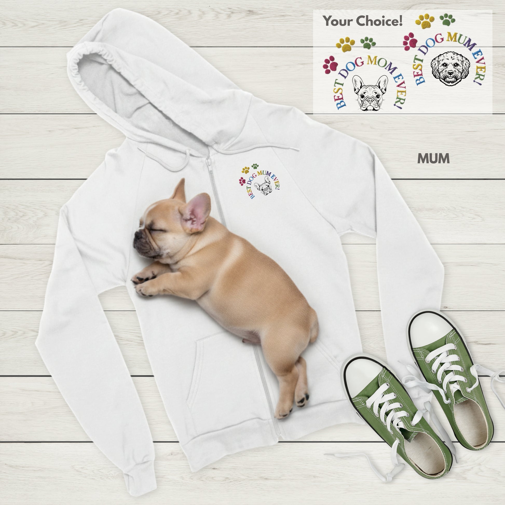 White Zip hoodie with Best Dog Mum Ever! and French Bulldog embroidery, sleeping Frenchie puppy, and green sneakers on a light wooden floor.
