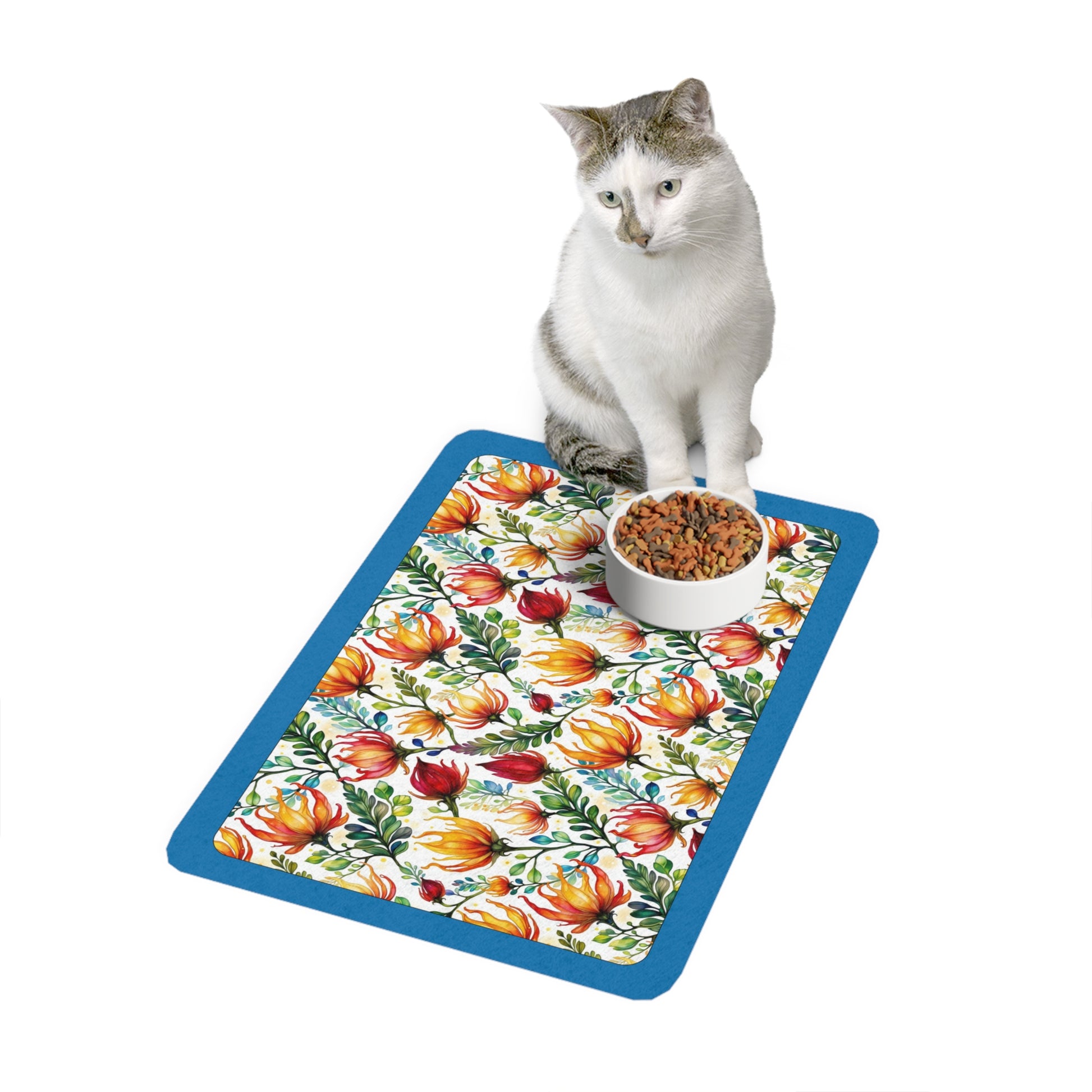 Bright Protea flowers and teal boarder on a mat with a cat sitting on the mat/