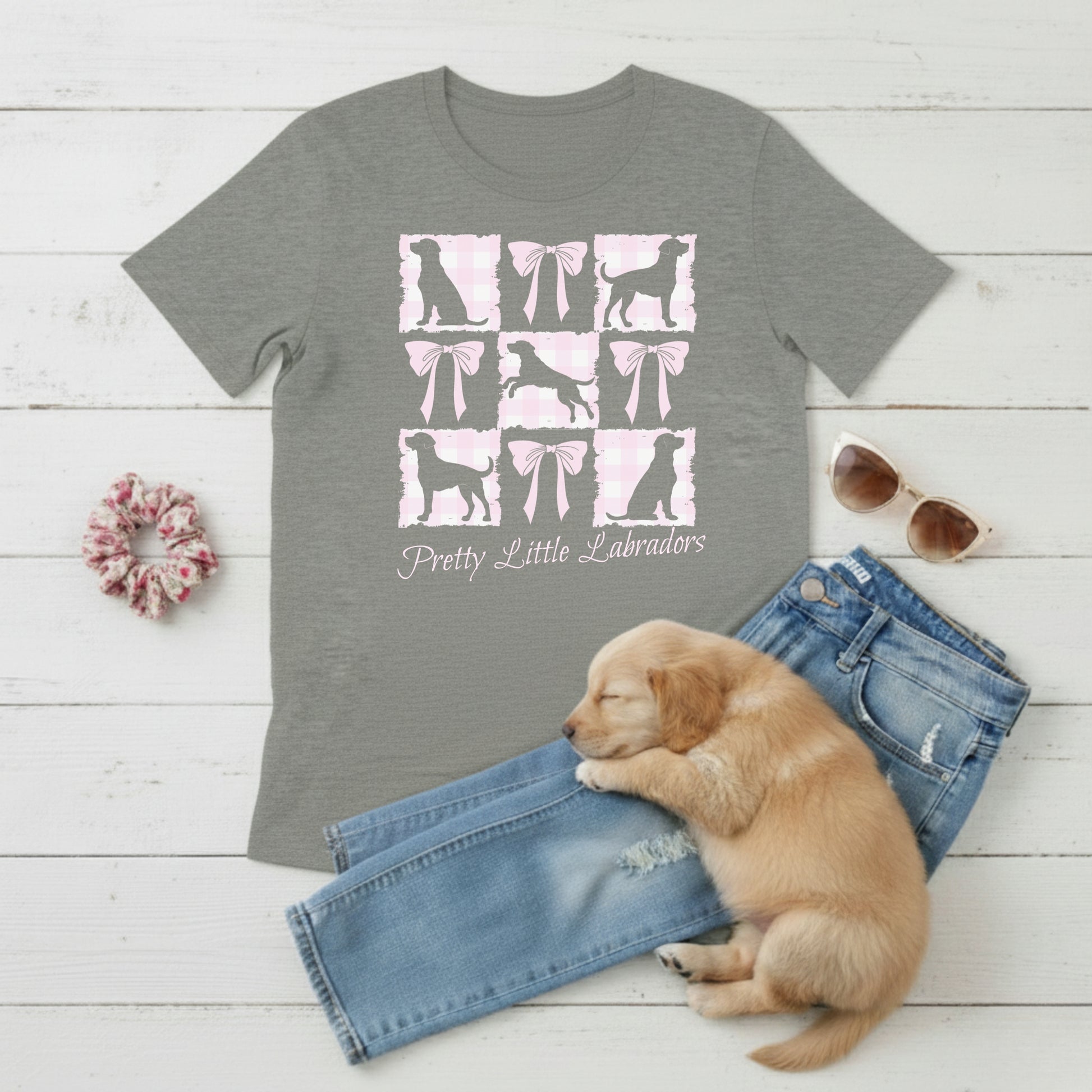  a Bella Canvas 3001 Athletic Heather Grey t-shirt with a Coquette Pink Bows & Checks Labrador Mum design flat lay with wardrobe suggestion and cute puppy. Custom Text choice - Pretty Little Labradors