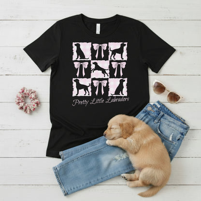  a Bella Canvas 3001 Black t-shirt with a Coquette Pink Bows & Checks Labrador Mum design flat lay with wardrobe suggestion and cute puppy. Custom Text choice - Pretty Little Labradors