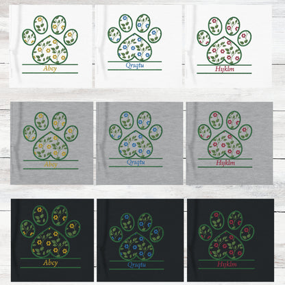 Set of floral paw print designs on white, grey and black sweatshirt backgrounds. Cottagecore retro floral design is shown in yellow, blue, and pink for each sweatshirt colour. The background of the image is a light wooden surface.