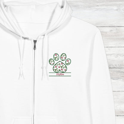 White hoodie with a embroidery floral paw print design close up with pet's name option on a wooden surface
