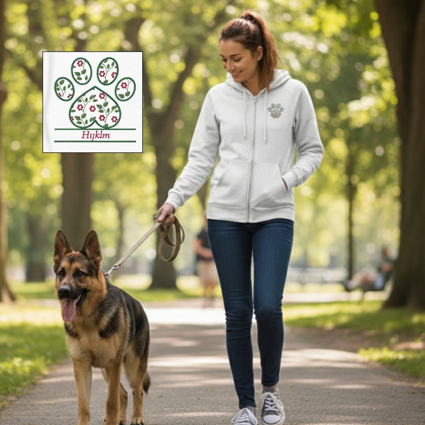 Woman wearing an eco-friendly white zip front hoodie with a cottagecore pink floral embroidery design on left side. She is walking her German Shepard in a park area. 