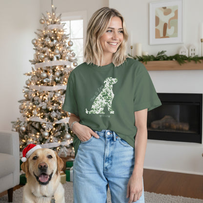Woman wearing a green 100% cotton t-shirt with a Labrador Floral graphic in a living room with a Christmas tree and a happy Lab wearing a Santa hat.